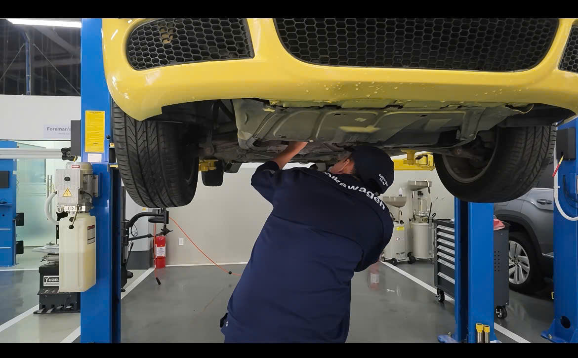 Kỹ thuật viên thay dầu động cơ cho xe Volkswagen tại đại lý chính hãng.